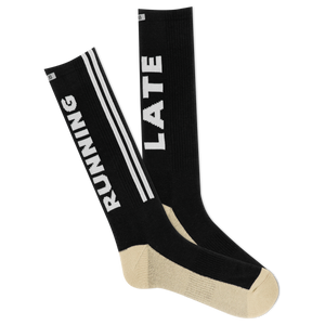 A pair of black and beige crew socks with 'RUNNING LATE' text and stripes.