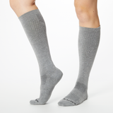 Front profile of a person wearing gray Dr. Scholl's knee high compression socks.