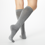 Back profile of a person wearing gray Dr. Scholl's knee high compression socks. thumbnail