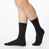Side profile of a woman wearing black Dr. Scholl's crew socks