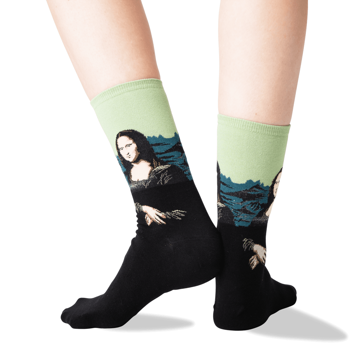 A pair of crew socks worn on a person's legs, featuring a black lower half with a printed Mona Lisa design and a light green upper half with blue mountain graphics.