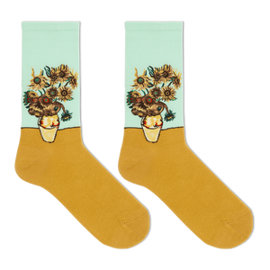 A pair of crew socks featuring a classic Van Gogh-inspired sunflower and chrysanthemum floral print on the upper half, with a solid mustard yellow lower half and a pale mint green cuff.
