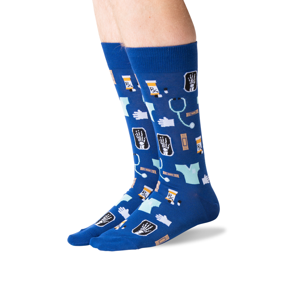 A pair of crew socks worn on lower legs, featuring a medical-themed print with X-rays, stethoscopes, pills, and medical icons on a royal blue background.
