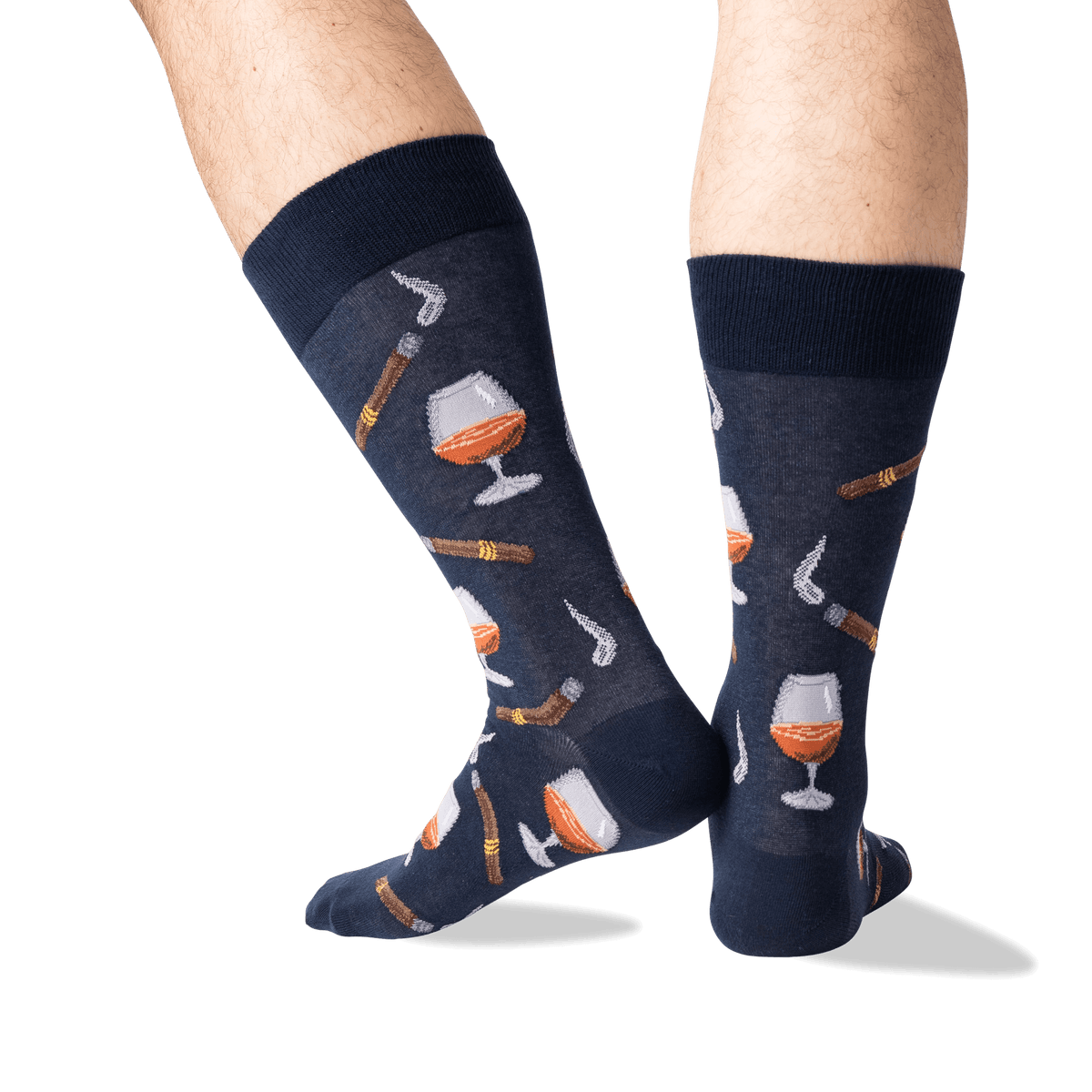 A pair of navy blue crew socks with a pattern of whiskey glasses, cigars, and smoking pipes, shown on a person's legs against a white background.