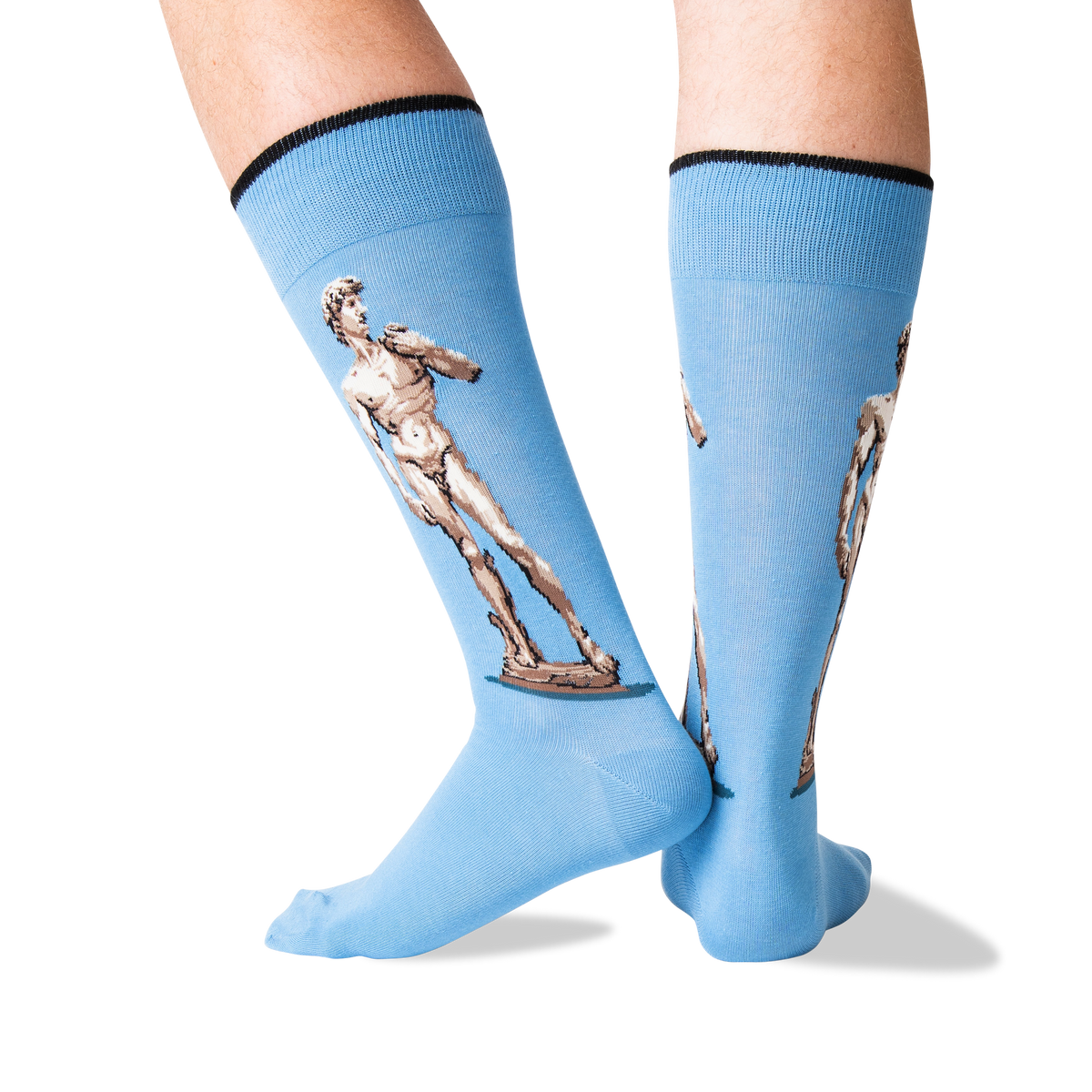 Light blue knee-high socks with black ribbed cuffs and printed illustrations of Michelangelo's David statues on the legs, shown on a model's feet against a white background.
