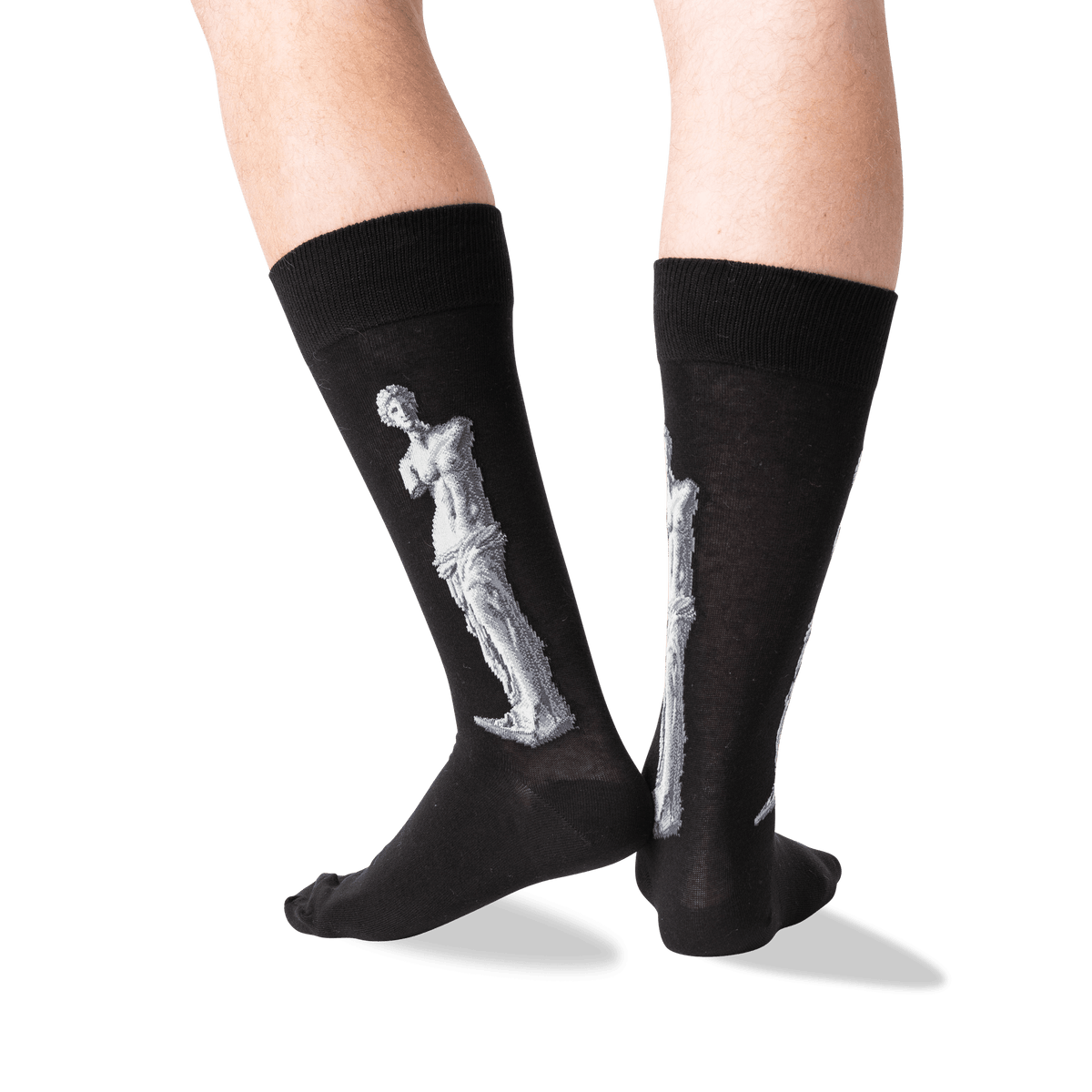 A pair of black crew socks worn on a person's legs, featuring a large white sculpture design on the side of each sock, photographed against a clean white background.