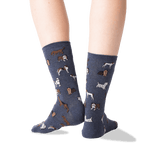 Blue socks with dog pattern worn by a person on a white background
