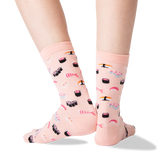 A pair of light pink crew socks with a sushi print, shown on a person's feet against a clean white background.