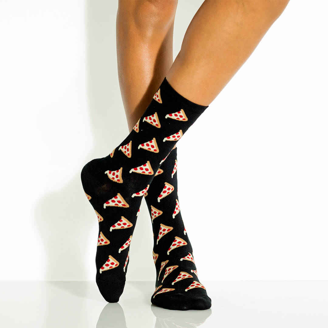 Black socks with pizza pattern worn by a woman on a white background