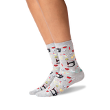 A pair of light gray crew socks with a colorful cartoon pattern of sewing machines, shown on a model's feet against a white background. thumbnail