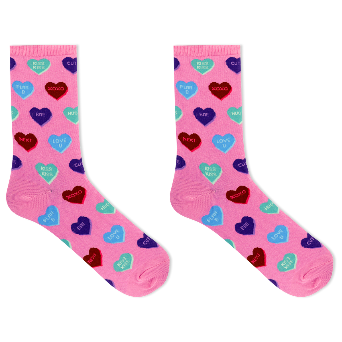 A pair of pink crew socks with an all-over pattern of colorful heart candies in red, blue, purple, and green, each printed with Valentine's themed phrases like 'Kiss Kiss', 'Love You', and 'HUGS'.