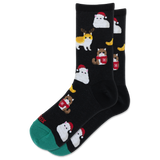 A pair of black crew socks with a repeating pattern of cute cats dressed in winter outfits, including Santa Claus and a reindeer, with a green toe cap and heel.