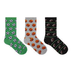 Three pairs of crew socks displayed side by side on a plain white background. The left pair is green with black and white soccer ball patterns, the middle pair is gray with orange basketball patterns, and the right pair is black with brown football patterns and thin green stripes.