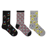 Three pairs of novelty crew socks displayed side-by-side on a plain white background. The left pair is black with colorful cartoon skateboarder prints.