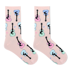 A pair of light pink crew socks with a repeating pattern of cartoon guitars in pastel pink, blue, and mint green, displayed on a clean white background.