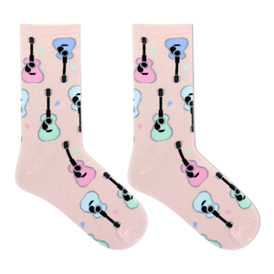 A pair of light pink crew socks with a repeating pattern of cartoon guitars in pastel pink, blue, and mint green, displayed on a clean white background.