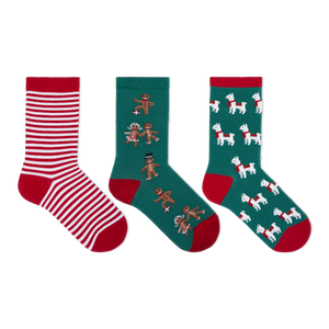 Three pairs of Christmas-themed crew socks displayed side-by-side on a plain white background. The left pair features red and white horizontal stripes with a red toe and heel.