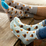 Two pairs of socks with ice cream cone pattern on a wooden surface.