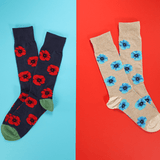 Two pairs of socks with floral patterns on a two-tone blue and red background. thumbnail