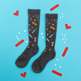 Gray knee-high socks with medical-themed pattern on a blue background with red and white accents. thumbnail
