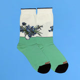 Green socks with floral 'Irises' design by Van Gogh on a blue background