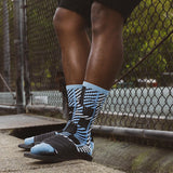 Person wearing black and blue patterned socks with a blurred background thumbnail