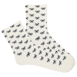 White women's socks with black bow pattern on a white background