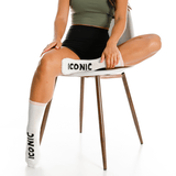Person sitting on a chair with 'Iconic' branding, wearing matching socks and shorts.