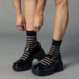 Black platform shoes with striped socks on a gray background thumbnail
