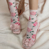 Floral-patterned socks and sandals on a textured surface thumbnail