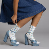 Person wearing denim platform shoes with white socks featuring blue hearts on a gray background thumbnail