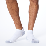 Front profile of a person wearing white MERRELL socks with black and gray accents on the heel and toe.