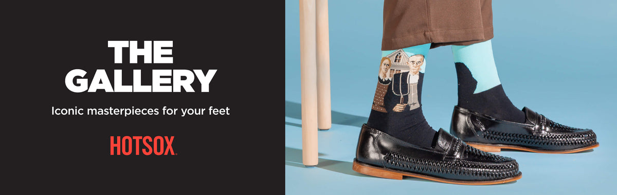 A lifestyle promotional image showing a person's feet wearing black leather loafers and patterned socks, standing against a light blue background next to a black graphic panel with the text 'THE GALLERY: Iconic masterpieces for your feet,' and the HOTSOX logo.