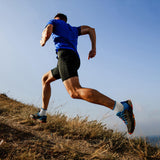Person running on a trail with a clear blue sky