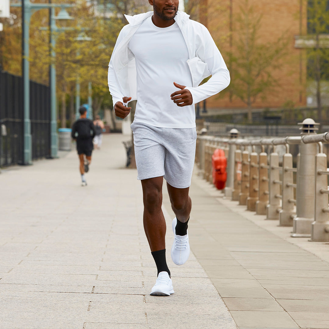 Man running on a sidewalk wearing a white outfit