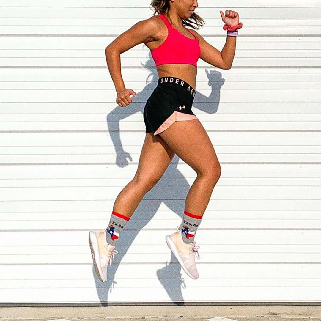 Person running outdoors with a white wall background