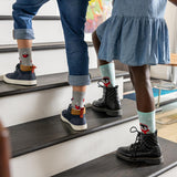 Two children wearing socks with cartoon characters on a staircase. thumbnail