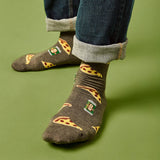 Person wearing socks with pizza slice and beer can designs on a green background thumbnail