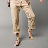 Person wearing beige pants and patterned socks with cars and surf boards on a gray background