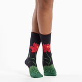 Black socks with red flower designs worn by a person on a white background thumbnail
