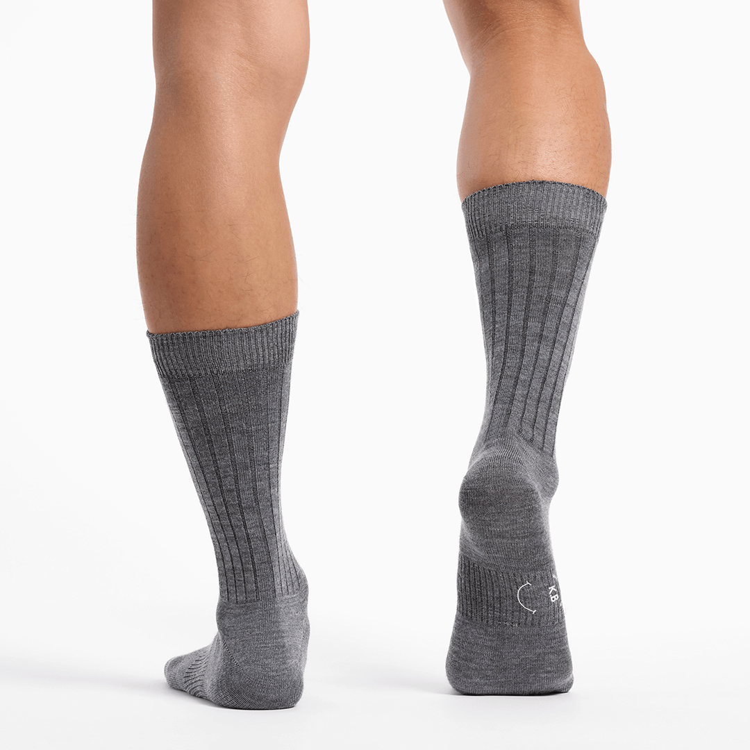 Gray socks worn by a person on a white background
