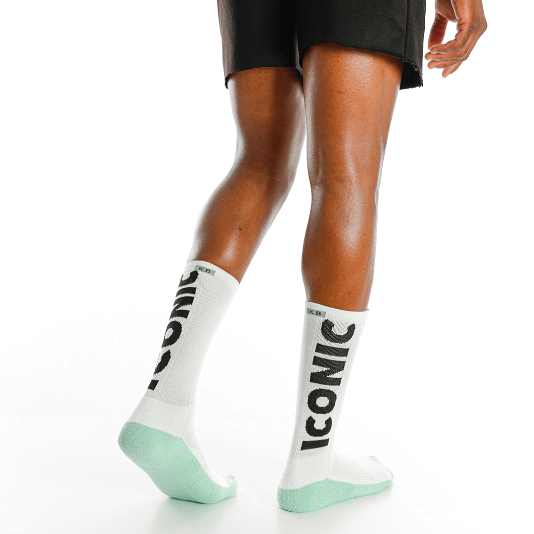 White socks with 'Iconic' branding worn by a person on a white background