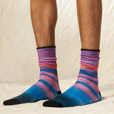 Colorful striped socks worn by a person on a neutral background thumbnail