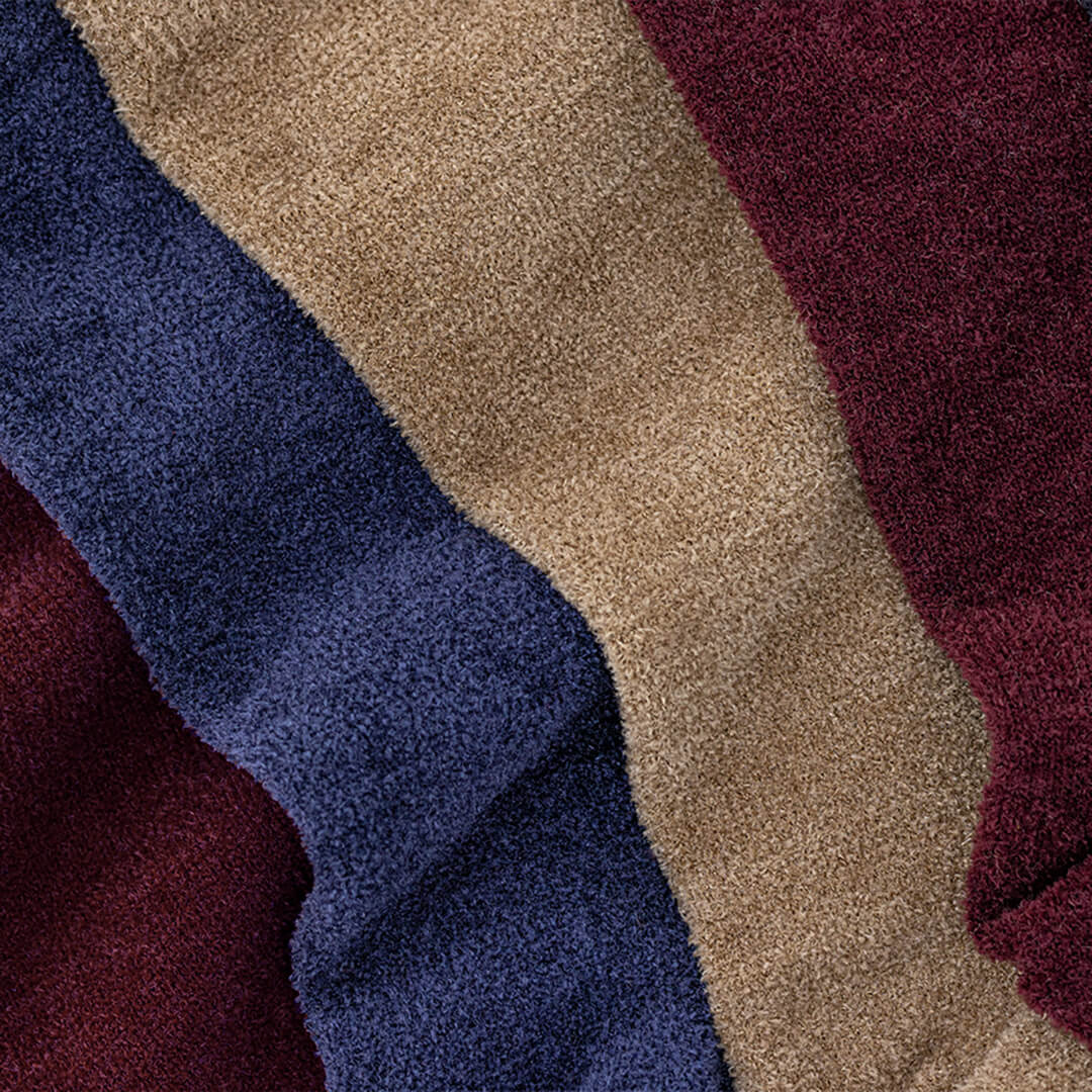 Close-up of blue, beige, and red velvet socks.
