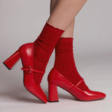 Red high-heeled shoes with matching socks on a neutral background thumbnail