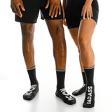 Two people wearing black socks with visible branding on a white background