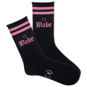 K.Bell women's black roll top socks with pink varsity stripes at the top of the cuff, a phrase in gothic lettering saying 'Babe' and a rhinestone heart.